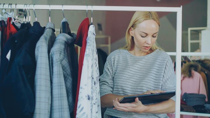 Small business owner reviewing inventory in her clothing store