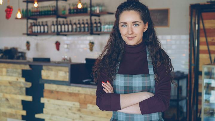 Small business owner smiling inside her coffee shop
